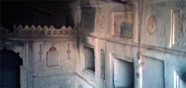 External wall construction with open storage areas and a qatiya wall