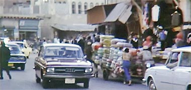Porters moving a heavy load through the suq, 1968 – image developed from a video with permission from glasney on YouTube
