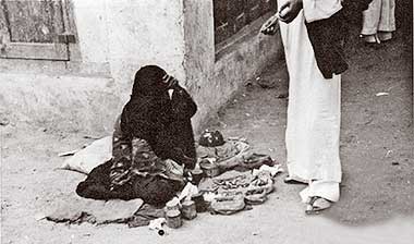A woman selling small items in the suq in the 1950s – courtesy of Mohammad Naseer